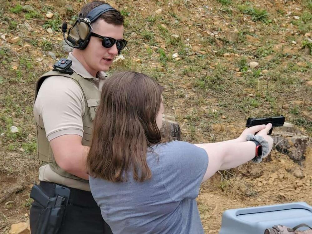 Deputy training citizen on firing range